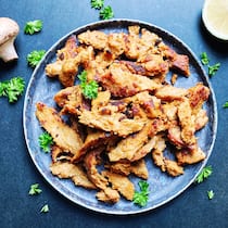 Seitan ist viel mehr als ein Fleischersatz Ein Teller mit Seitan sowie einem Pilz und einer Limette daneben. Warum Seitan die bessere Wahl ist zum Poulet.