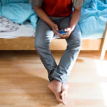 Geflüchtete müssen ihre Handys jetzt durchsuchen lassen Ein unbegleiteter minderjähriger Asylsuchender (UMA) blickt auf sein Handy.