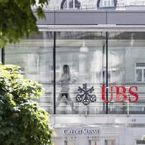 Der Chef will mich zurück im Büro. Muss ich? Ein Frau laeuft zwischen den beiden Logos der Banken UBS und Credit Suisse, aufgenommen am Montag, 12. Juni 2023 in Zuerich. Heute verkuendete die nunmehr einzige Schweizer Grossbank in einem offenen Brief: Die Uebernahme der Credit Suisse durch die …