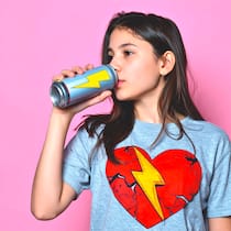 Red Bull und Co. greifen Kinderherzen an Jugendliche, ca. 13 Jahre, trinkt aus einer Dose mit gelbem Blitz Logo, auf dem T-Shirt hat es ein Herz mit Blitz und Rissen. Thema: Energy Drink schadet Kinderherzen.
