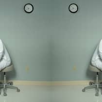 Jetzt soll die Bevölkerung noch mehr zahlen Ein Arzt sieht hinter den Vorhang eines Patientenabteils.