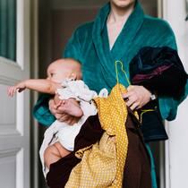 Frauen leisten Gratisarbeit für 322 Milliarden Franken A single mother with her baby trying to get dressed in the morning, carrying clothes to get changed.
1127652816