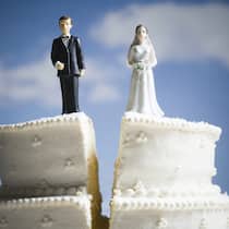 So wird die Altersvorsorge aufgeteilt Ein Hochzeitskuchen, auf dem zwei Figuren stehen, die eine Braut und einen Bräutigam zeigen, ist in der Mitte geteilt worden.