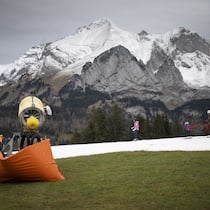 Weiterfahren – trotz allem Skifahrer auf einer Kunstschneepiste mitten in grüner Landschaft in Wildhaus