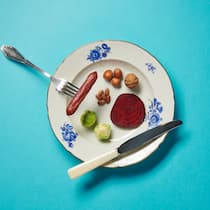 Fleischlos glücklich – so gehts Teller mit Gabel, Messer, Wurst, Nüssen, Rosenkohl und Randen. Die Fakten sind klar: Weniger Fleisch essen ist besser für die Umwelt. Und unsere Gesundheit. Beobachter-Redaktorin Julia Hofer hats ausprobiert – und ist begeistert.
