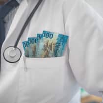 Diese fünf Professoren kassieren am meisten Lead: Ein Genfer steht an der Spitze – die Top 5 der Mediziner, die sich von der Pharmaindustrie Kongressbesuche und Beratungsaufträge bezahlen lassen. Arzt mit Geldscheinen in der Brusttasche