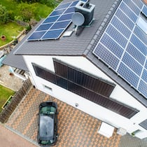 Solarstrom selbst speichern – lohnt sich das? Ein Einfamilienhaus mit Fotovoltaikanlage und Elektroauto auf der Auffahrt. Lohnt es sich, in einen Energiespeicher zu investieren?