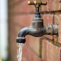 Übernehmen bald private Firmen? Wasserhahn an einer Hauswand