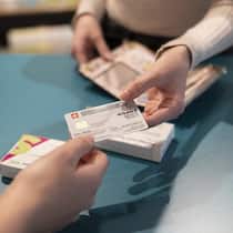 So wollen einzelne Kantone jetzt die Prämienzahler entlasten Frau zeigt einer anderen Frau die Krankenkassenkarte - Wer profitiert von höheren Steuerabzügen für Krankenkassenprämien? Der Mittelstand oder Gutverdienende? In mehreren Kantonen laufen Initiativen. Ein Überblick