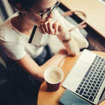 Auf Onlineshop hereingefallen – was tun? Frau, die Probleme mit der Kreditkarte in einem Kaffee hat.