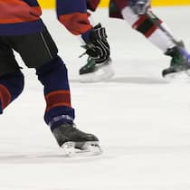 Dank Spenden weiter Eishockey spielen Zwei Eishockeyspieler auf dem Eis, man sieht nur die Beine bis zum Rumpf