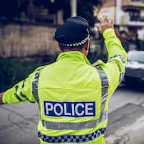 Nach den Ferien folgt die Busse Ein Verkehrspolizist im Ausland steht an einer Strasse und winkt einen Autofahrer zur Kontrolle heraus. Das sollten Sie tun, wenn Sie im Ausland eine Busse kassiert haben.