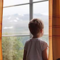 Ausnahmezustand im Kinderheim Kind schaut aus dem Fenster