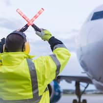 Piloten der Lufthansa könnten bald die Arbeit niederlegen Ein Fluglotse weist einem Piloten den Weg auf dem Flughafen - Wenn ein Flug ausfällt oder verspätet aufgrund eines Streiks startet, haben Flugpassagiere gemäss EU-Verordnung Rechte. Welche das sind, erklärt der Beobachter.