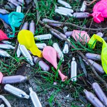 In 30 Sekunden high – muss die Politik reagieren? Rahmbläserkapseln und farbige Ballons liegen auf einer Wiese. Das GAs wird in die Ballons geblasen und aus diesen inhaliert.