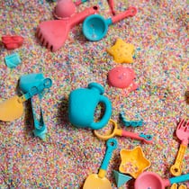 Überall lauert Gift im Plastik Farbiges Plastikspielzeug im Sand, teils vergraben