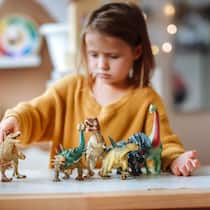 Wenn liebevolle Eltern ihre Kinder ungewollt vernachlässigen sad little girl plays with dinosaur figurines at home alone.