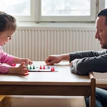 Was Kinder durch Gesellschaftsspiele lernen können Ein Vater spielt mit seiner kleinen Tochter ein Gesellschaftsspiel. Kleinkinder lernen durch das Spielen wichtige Fähigkeiten für ihre Entwicklung. Eine Einschätzung einer Entwicklungspsychologin.