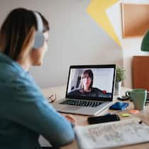 Arbeitgeberpflichten für das Büro zu Hause Eine junge Frau arbeitet im Homeoffice und ist in einer Videokonferenz.