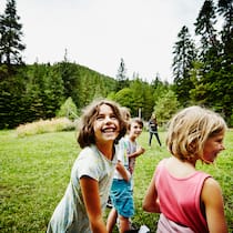 Dank Spenden ins Ferienlager Dank der Stiftung SOS Beobachter kann ein Alleinerziehender das Ferienlager für seine Kinder bezahlen. Fröhliche Kinder rennen über eine Wiese.