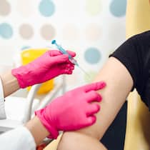 «Mir graut es vor Nadeln» Eine Ärztin mit rosaroten Handschuhen setzt zum Nadelstich am rechten Oberarm einer jungen Frau an.