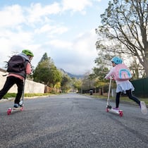 Ein grosser Schritt für Kleine Zwei kleine Schulkinder mit dem Trottinett auf dem Weg zur Schule.