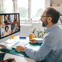 Die richtigen Tools fürs Homeoffice Geschäftsmann im Homeoffice hält über Videocall ein Meeting ab.