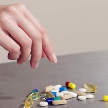 Wie süchtig machen Antidepressiva? Eine Frau greift nach einer Handvoll Tabletten