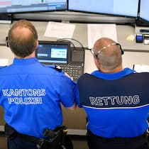 Haftet die Swisscom für Schäden? Zwei Beamte der kantonalen Notrufzentrale Aarau stehen vor mehreren Bildschirmen.