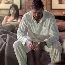 Wenn der Ehepartner Alkoholiker ist Ein Mann mit einem Glas Whisky sitzt auf dem Bett und streitet sich mit seiner Frau.