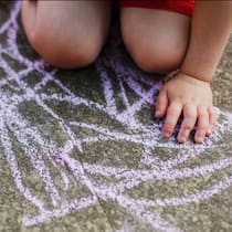 Dank Spenden doch noch in die Kinderkrippe Kind malt mit Kreide auf Strasse