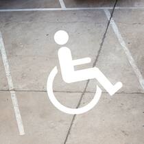 Das Kreuz mit dem Rotkreuz-Fahrdienst Rollstuhl-Logo auf Parkplatz