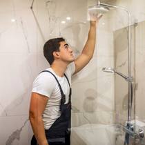 Zahlen Mieter für den Schlauch? Ein Handwerker begutachtet die Dusche in einem Badezimmer.