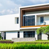 Jetzt zu einer festen Hypothek wechseln? Ein Familienhaus steht inmitten einer grünen Landschaft.