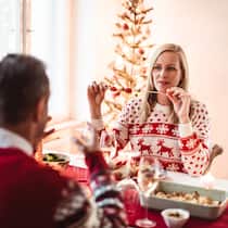 «Das Fest mit der Schwester ärgert mich jetzt schon» Zwei Geschwister feiern Weihnachten und sitzen am weihnachtlich geschmückten Esstisch.