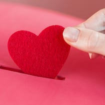 Geld spenden und vom Steuerabzug profitieren – das gilt Ein Herz wird in eine Sparbox gesteckt. Wer etwas spendet, erhält Steuervergünstigungen vom Staat.