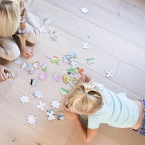 Platz da für Geschenke! So gelingt das grosse Ausmisten vor Weihnachten USA, Kalifornien, Pasadena, Hause, Wohnzimmer, Portrait, Familie, Junge und Maedchen liegen auf dem Boden und puzzeln1125574127