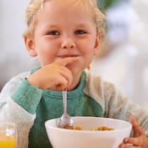 Müesli sind immer noch zu süss Ein Mädchen isst ein Müesli zum Frühstück.