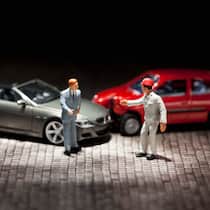 Haftung bei Unfall während der Probefahrt Zwei Miniaturfiguren streiten über ihren Autounfall