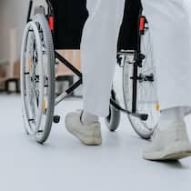 Junger Pfleger plündert Portemonnaies von Patienten Eine Pflegeperson schiebt Rollstuhl - Ein junger Pfleger beklaute in einer Aargauer Rehaklinik systematisch Patienten. Mit deren Kreditkarten finanzierte er sich ein Leben zwischen McDonald’s, Bars und Kioskbesuchen