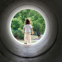 Neue Meldestelle gegen Kinderpornografie gestartet Blick durch eine Röhre auf ein Mädchen