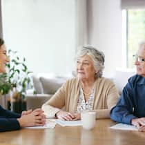 Letzte Fehler vermeiden Ein Senioren-Paar (Frau und Mann) sitzen am Tisch im Gespräch mit einer Beraterin