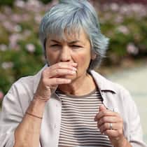 Alter schützt vor Allergien nicht Eine Frau geht an einer Blumenrabatte vorbei und muss niesen.