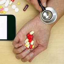 «Viele Gesunde messen fanatisch» Eine Frau hält symbolisch ein Stetoskop auf ihr Handgelenk, um den Puls zu messen.