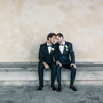 «Ich habe Mühe mit der Ehe für alle» Zwei schwule Männer sitzen in Hochzeitsanzügen auf einer Bank.