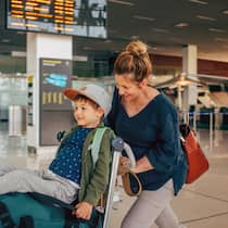 So kommen Sie stressfrei mit Kindern durch die Passkontrolle Frau mit Kind auf dem Kofferwagen am Flughafen - In den Sommerferien reisen viele ins Ausland. Wenn dabei ein Elternteil mit Kindern alleine unterwegs ist oder einen anderen Nachnamen hat, sind zusätzliche Dokumente wichtig