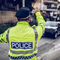 Nach den Ferien folgt die Busse Ein Verkehrspolizist im Ausland steht an einer Strasse und winkt einen Autofahrer zur Kontrolle heraus. Das sollten Sie tun, wenn Sie im Ausland eine Busse kassiert haben.