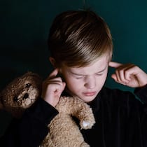 Das Leiden der Scheidungskinder Kind mit Teddybär im Arm hält sich Ohren zu