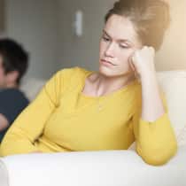 «Ich glaube, mein Mann ist depressiv» Mann und Frau sitzen einander abgewendet auf einem Sofa