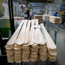 Bretter, die der Umwelt schaden Holzkerne für die Produktion von Skiern liegen in einer Fabrikhalle aufeinandergestapelt.